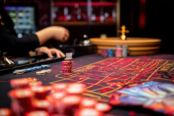 A glowing roulette wheel with cascading chips, symbolizing the engaging live and instant-win games available on 5666BET.